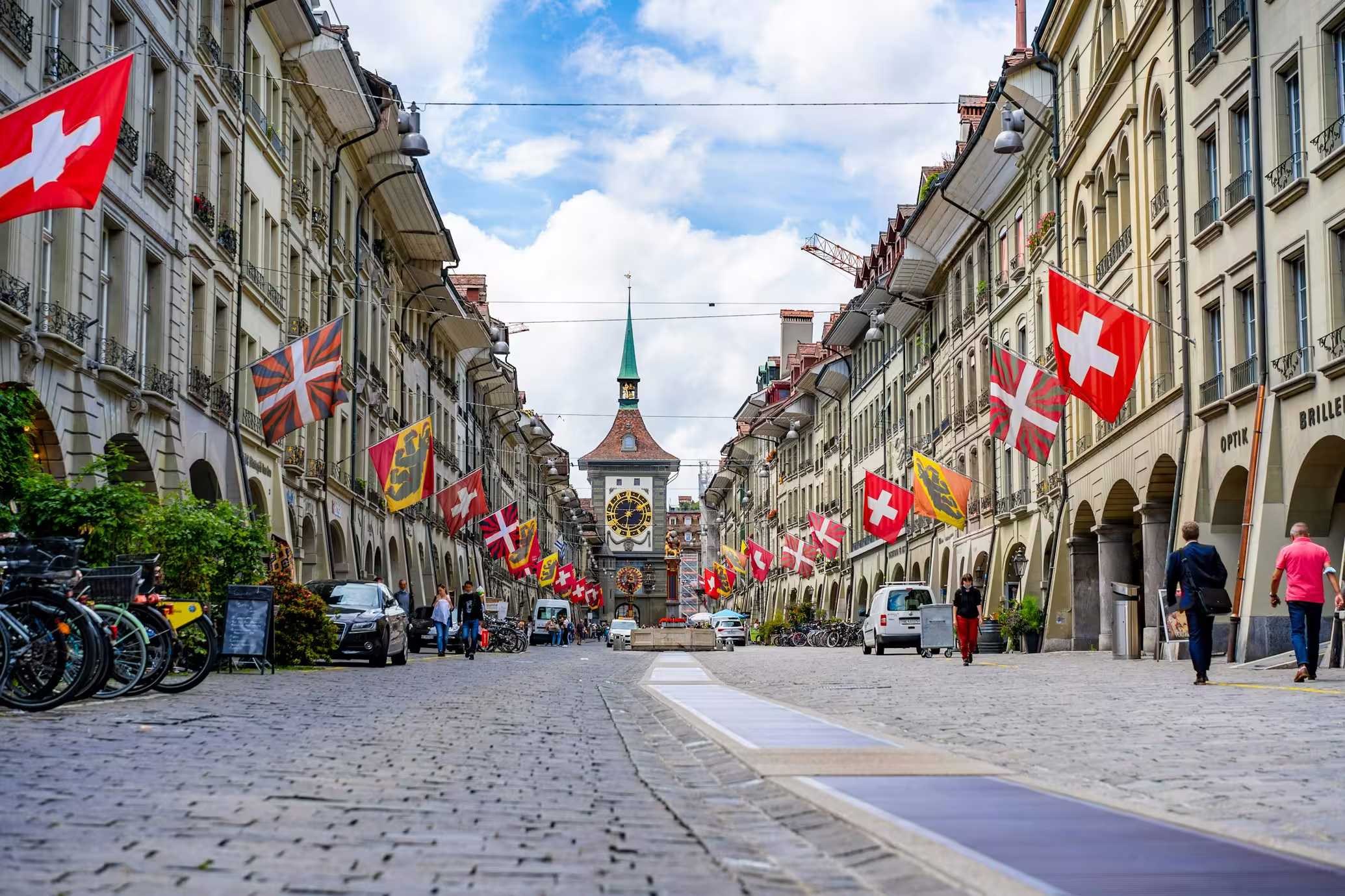 Bern old town street with Swiss flags — photo by Alin Andersen